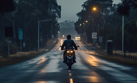 Motorcyclist on an Australian road at dusk, showcasing bright LED headlights, emphasizing the importance of ADR-compliant lighting for safety and visibility